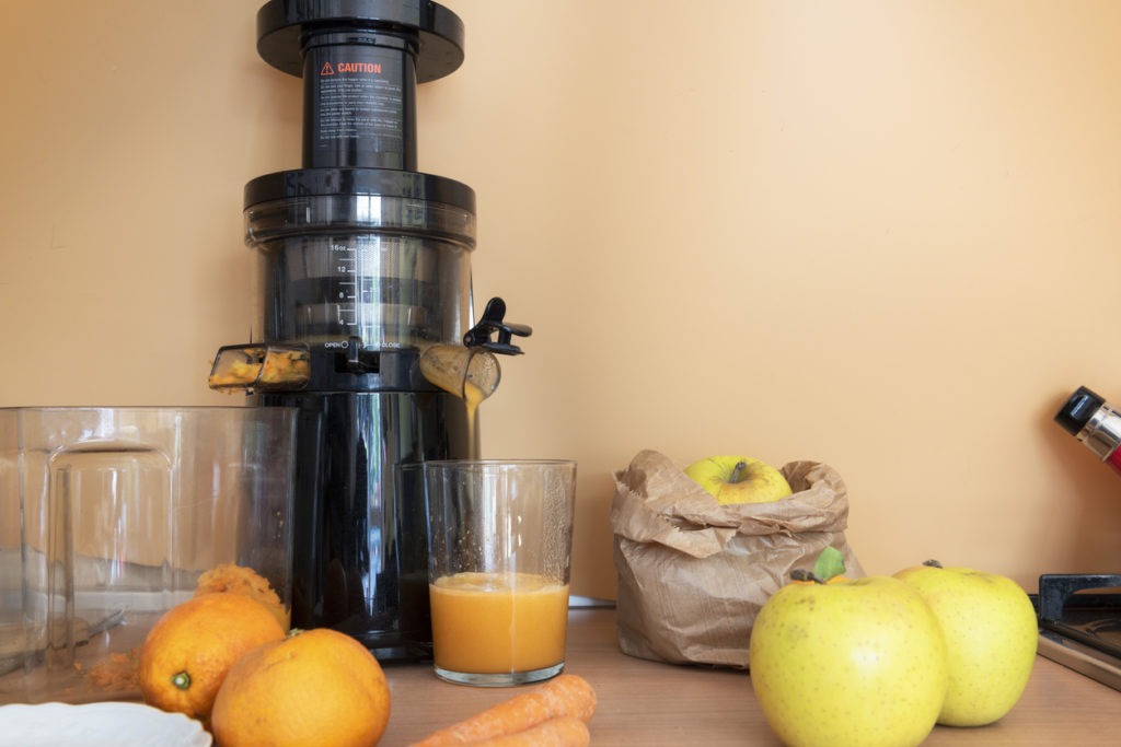 A centrifugal juicer with apples, carrot and orange