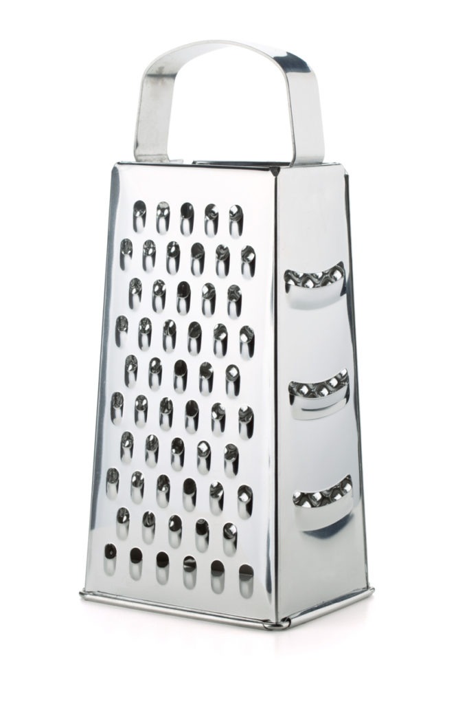 Metal grater with four different sides on white background