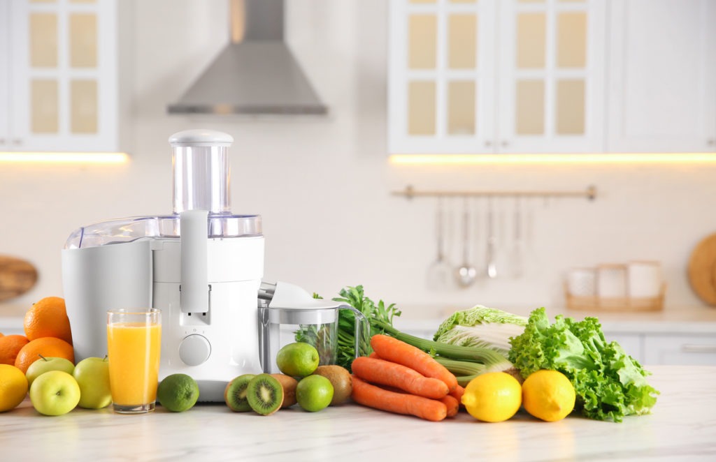 Modern juicer, fresh vegetables and fruits on table in kitchen