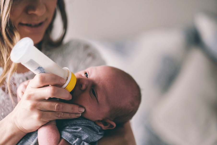 mother-feeding-her-baby-with-milk-using-a-baby-bottle