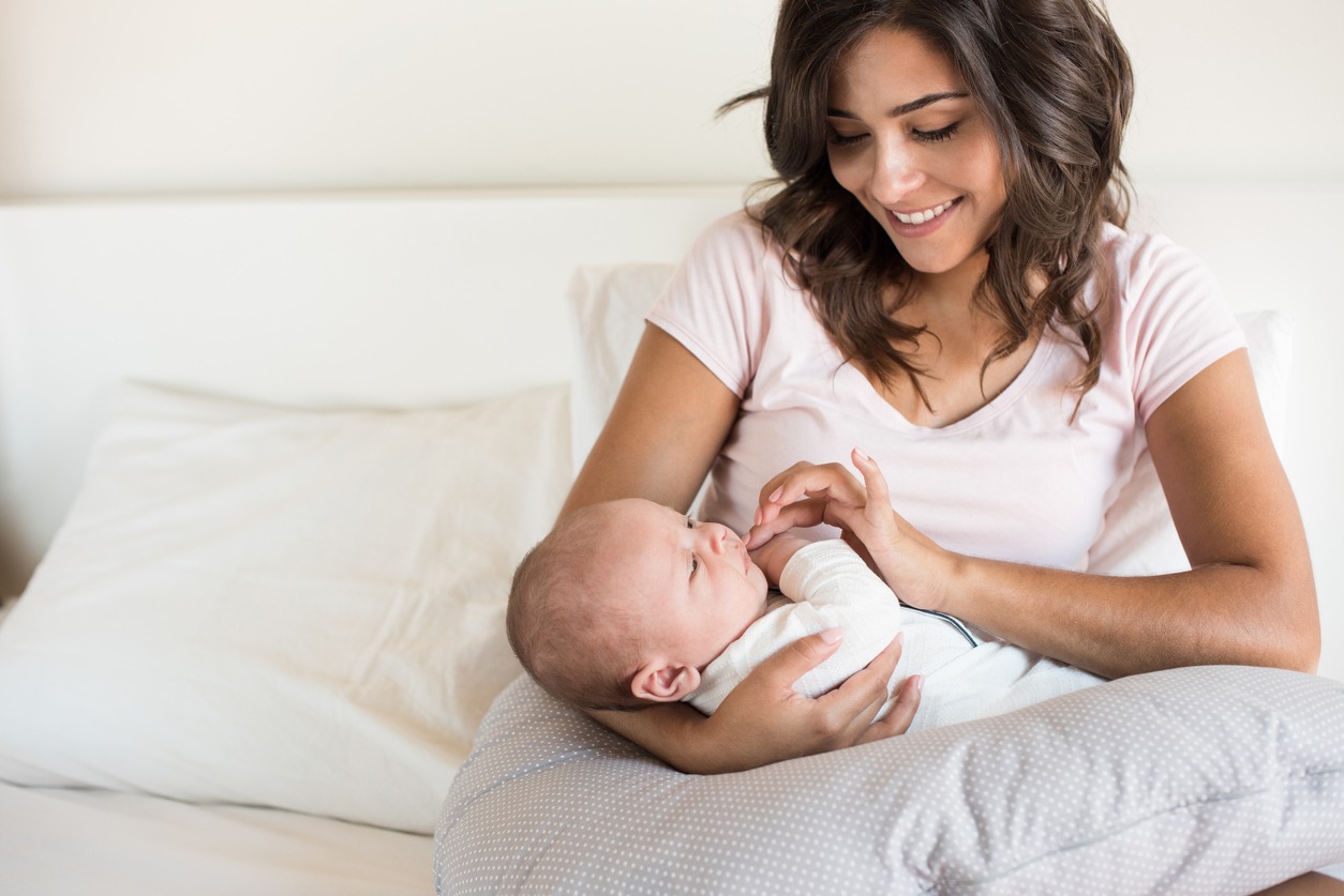 mother with baby on a nursing pillow