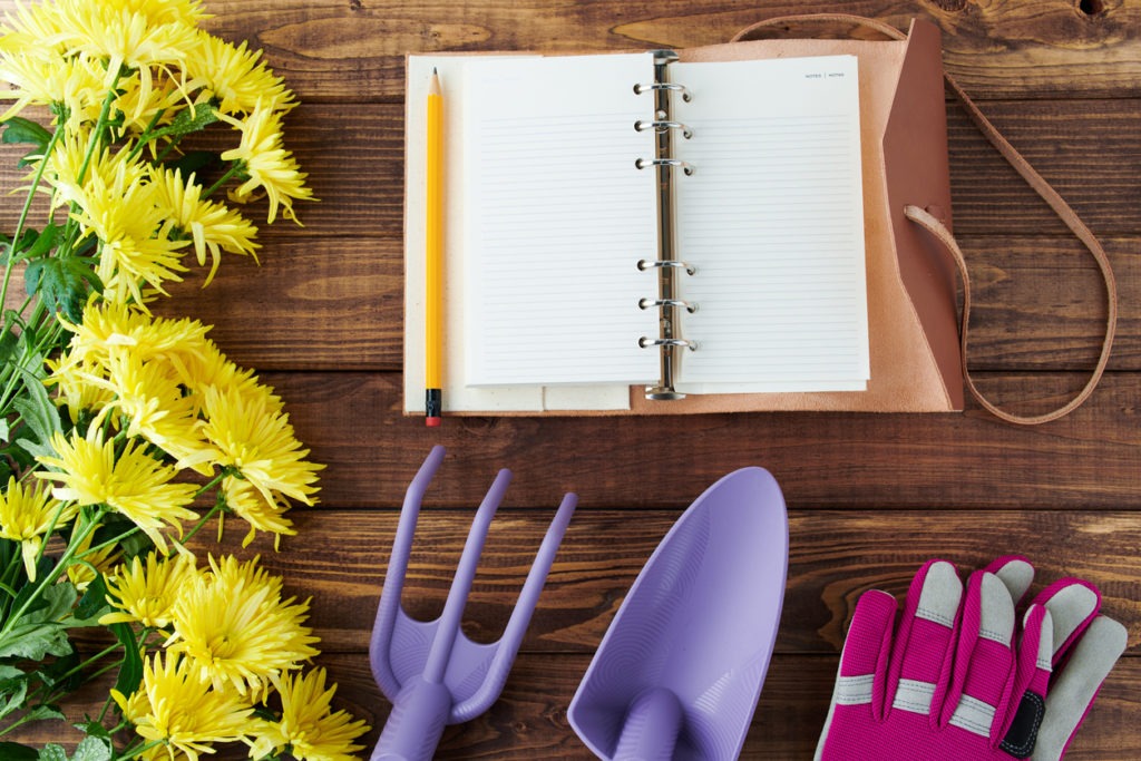 spring flat lay with notebook, gardening tools and gloves