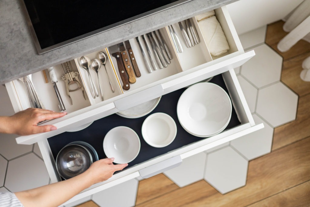 Top view modern housewife tidying up kitchen cupboard during general cleaning or tidying up