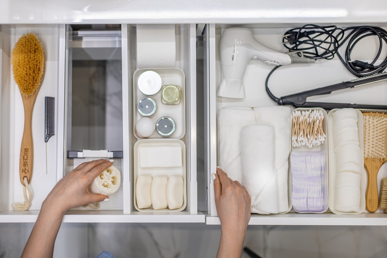 top-view-of-a-womans-hands-neatly-organizing-bathroom-amenities-and-toiletries-in-the-drawer