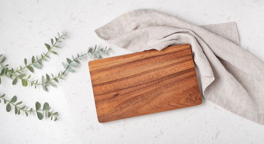 Wood cutting board with napkin and plant