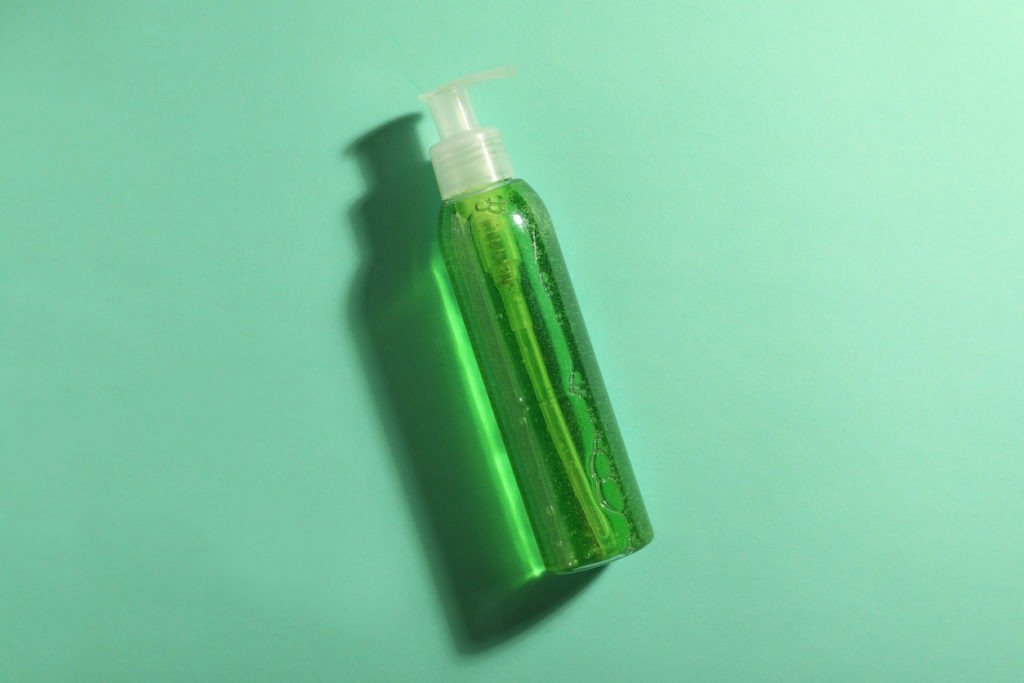 A bottle of green cosmetic gel. 