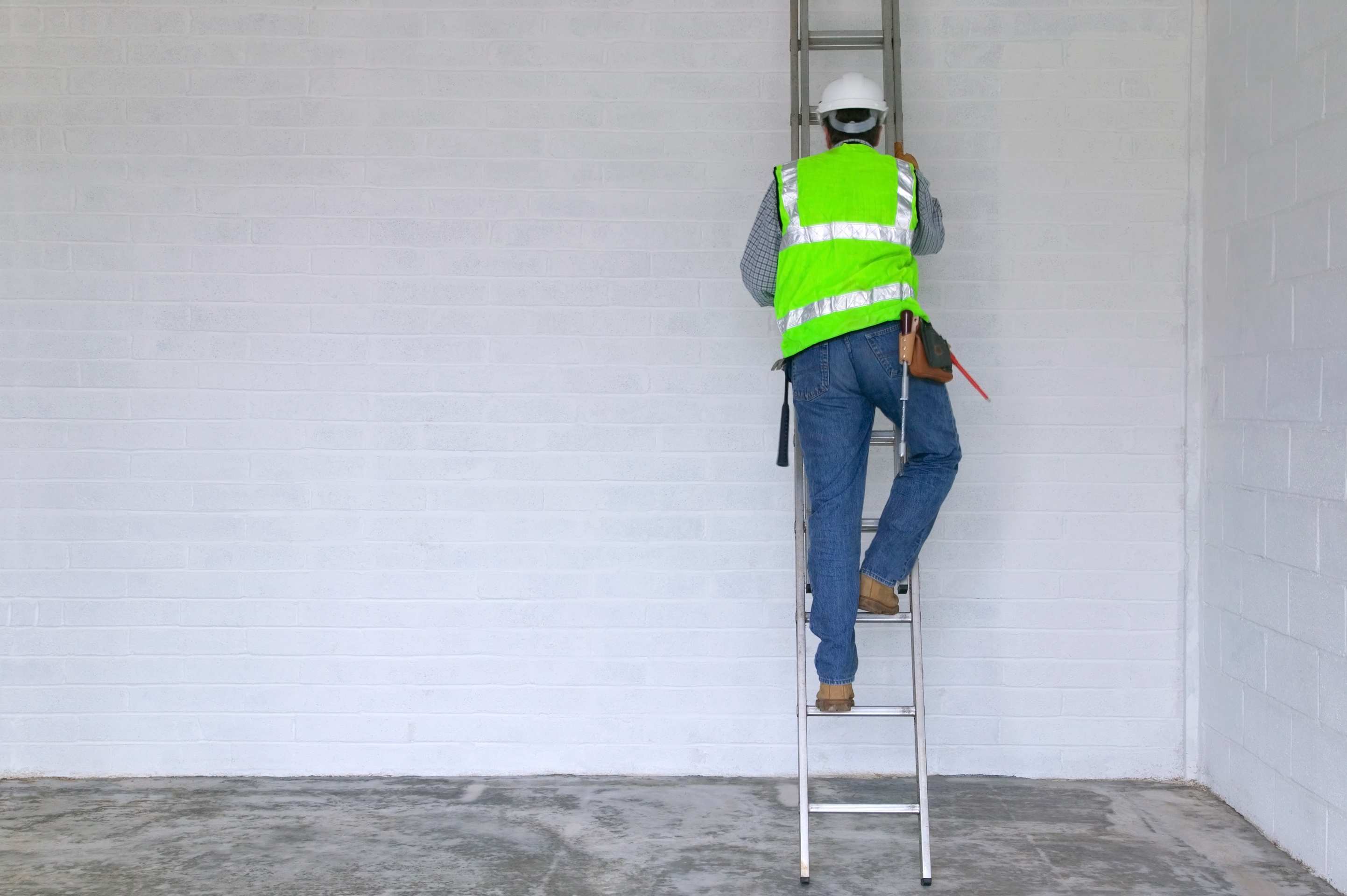 A construction employee climbing a ladder