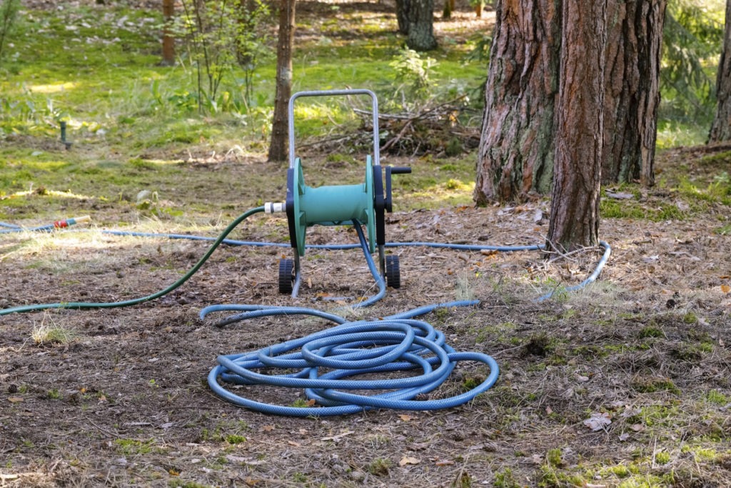 A garden hose unrolled from a reel