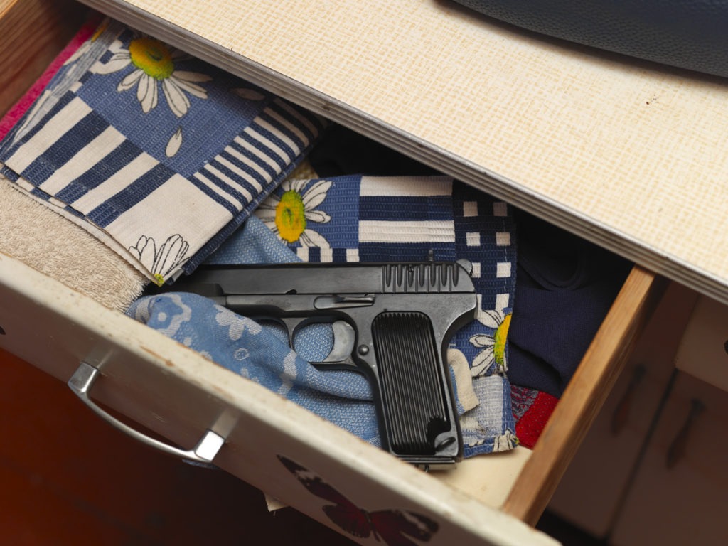 A handgun inside a nightstand drawer