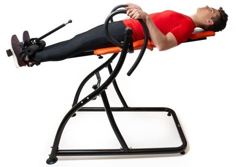 A man doing exercise on inversion table for his back pain