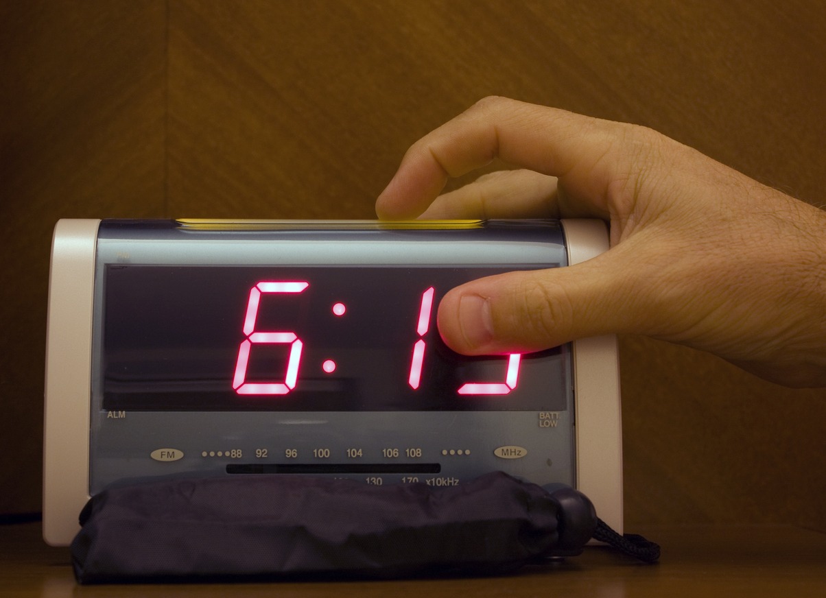 A person snoozing an alarm clock