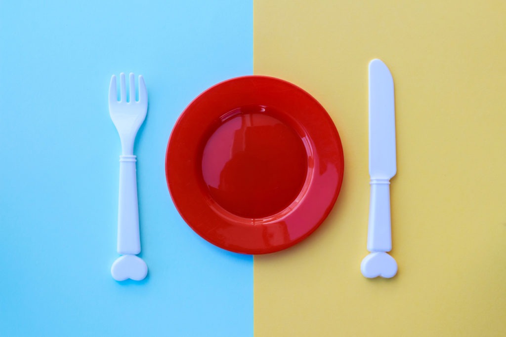 A plastic kid’s  plate with spoon and fork