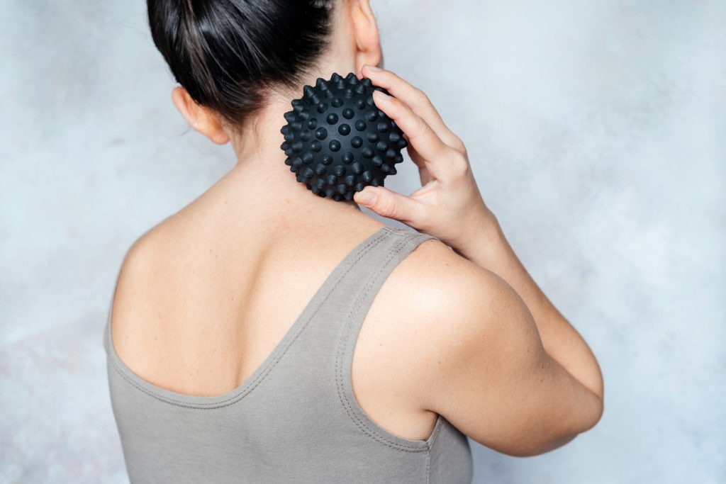 A woman using a spiky massage ball