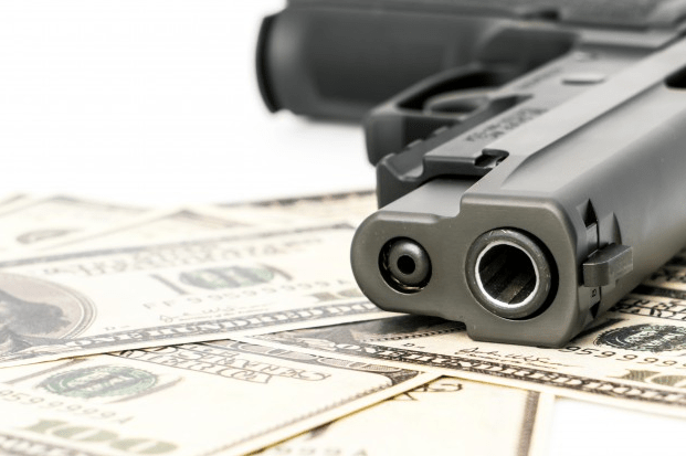 Close-up-image-of-a-pistol-and-dollar.