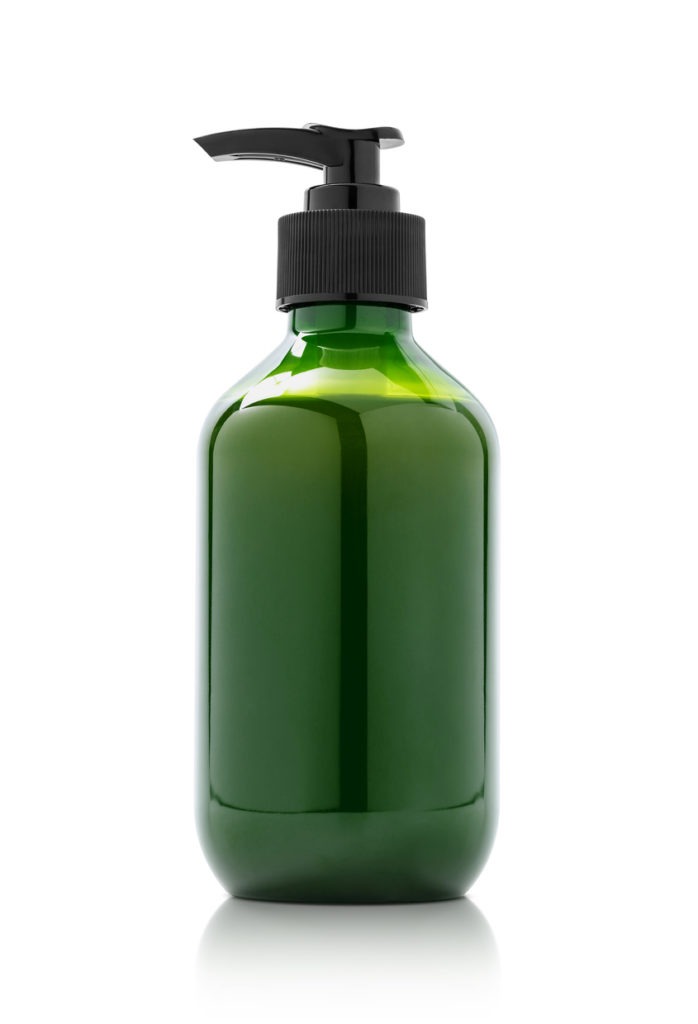 Green pump bottle with empty packaging for a cosmetic product, isolated on a white backdrop. 