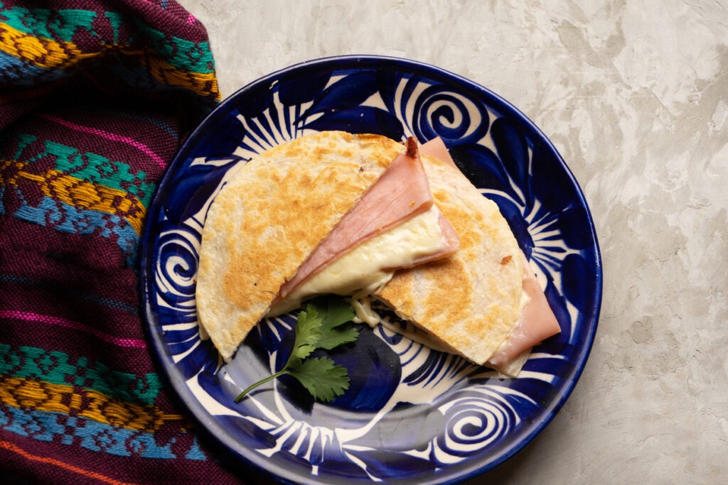 A flour tortilla-based quesadilla with ham and cheese