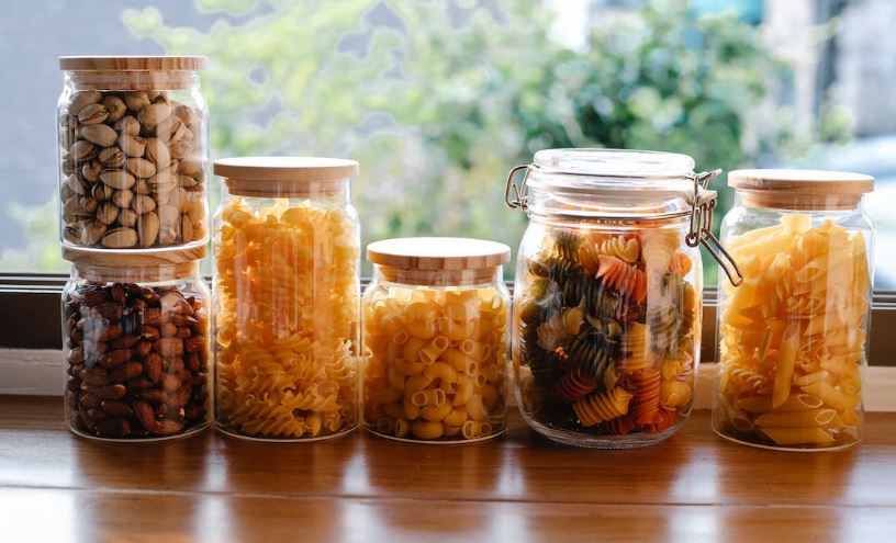 Jars with various raw pasta and nuts.