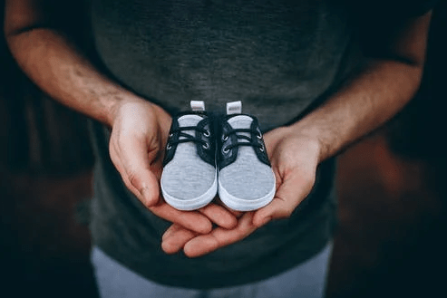 Man-holding-baby-shoes