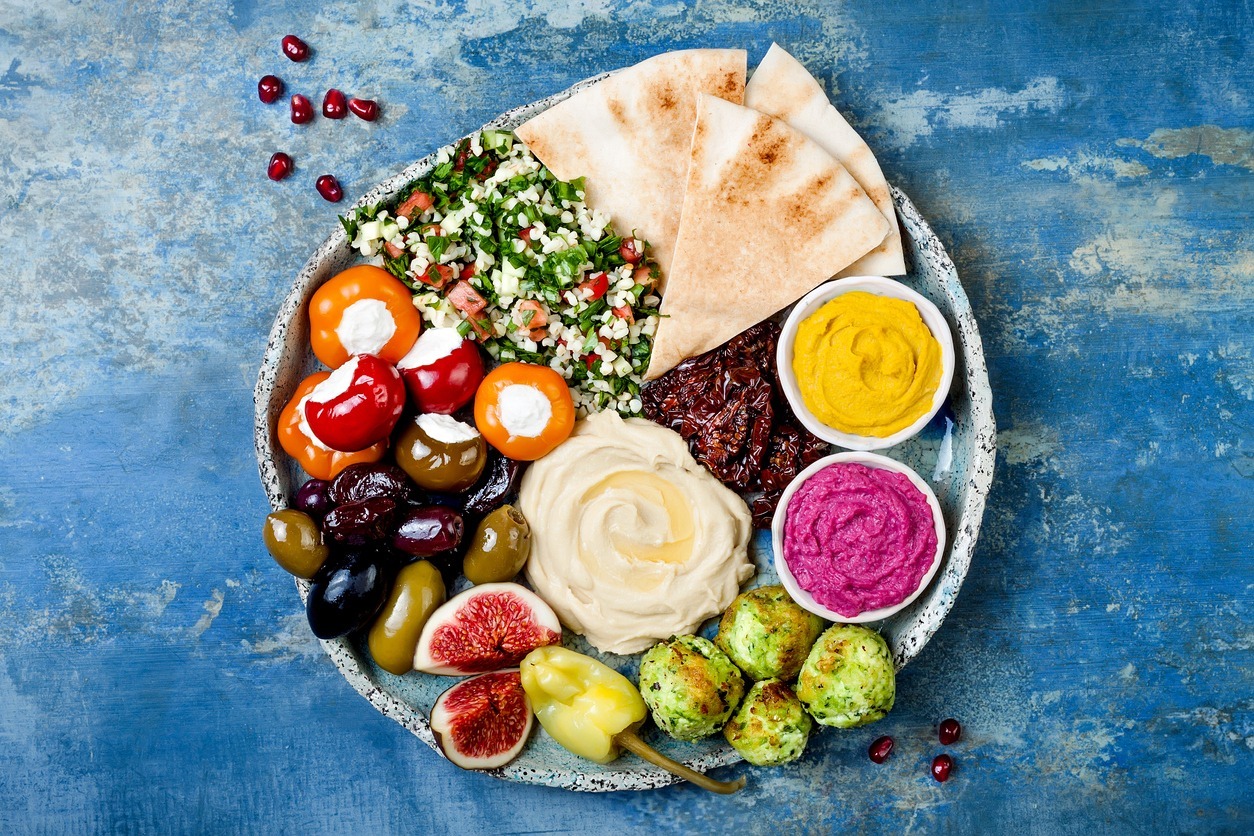 Middle-Eastern-meze-platter-with-green-falafel-pita-sun-dried-tomatoes-pumpkin-and-beet-hummus