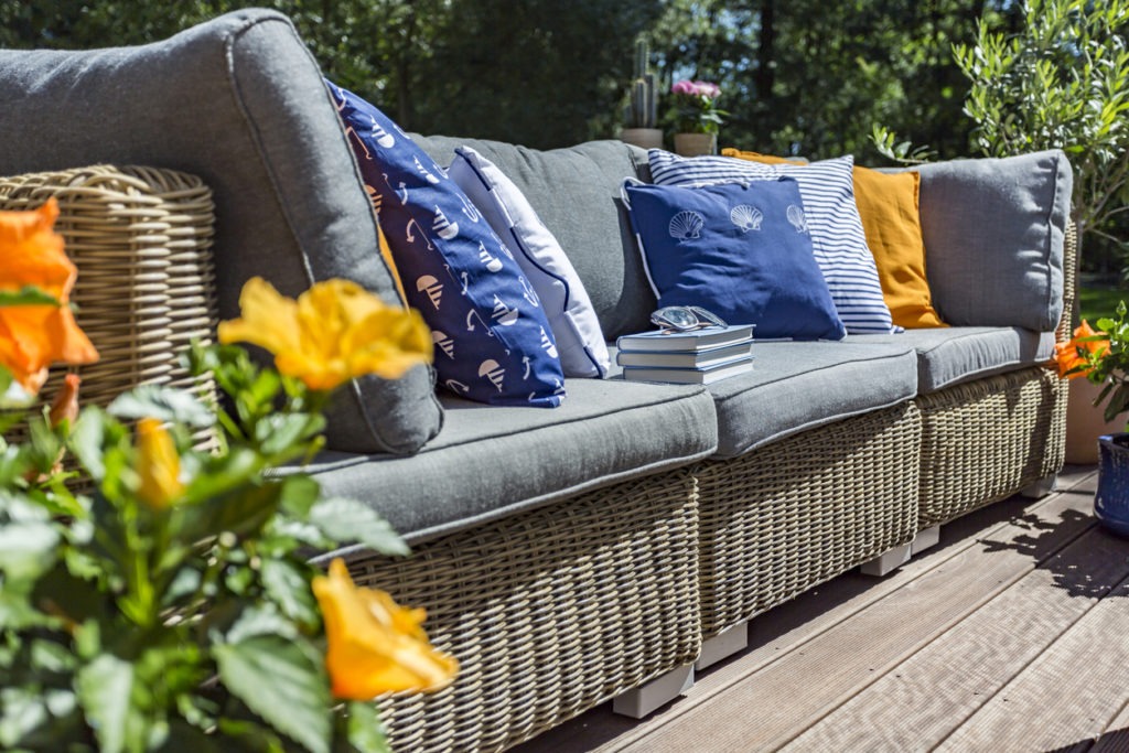 Rattan couch with blue cushions.