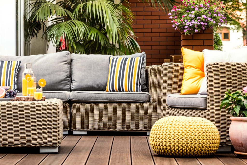 Several pieces of rattan furniture with different coloured cushions.