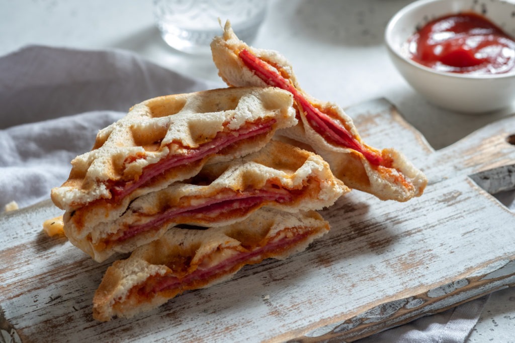 Sliced pizza waffles with ham, pepperoni, and cheese