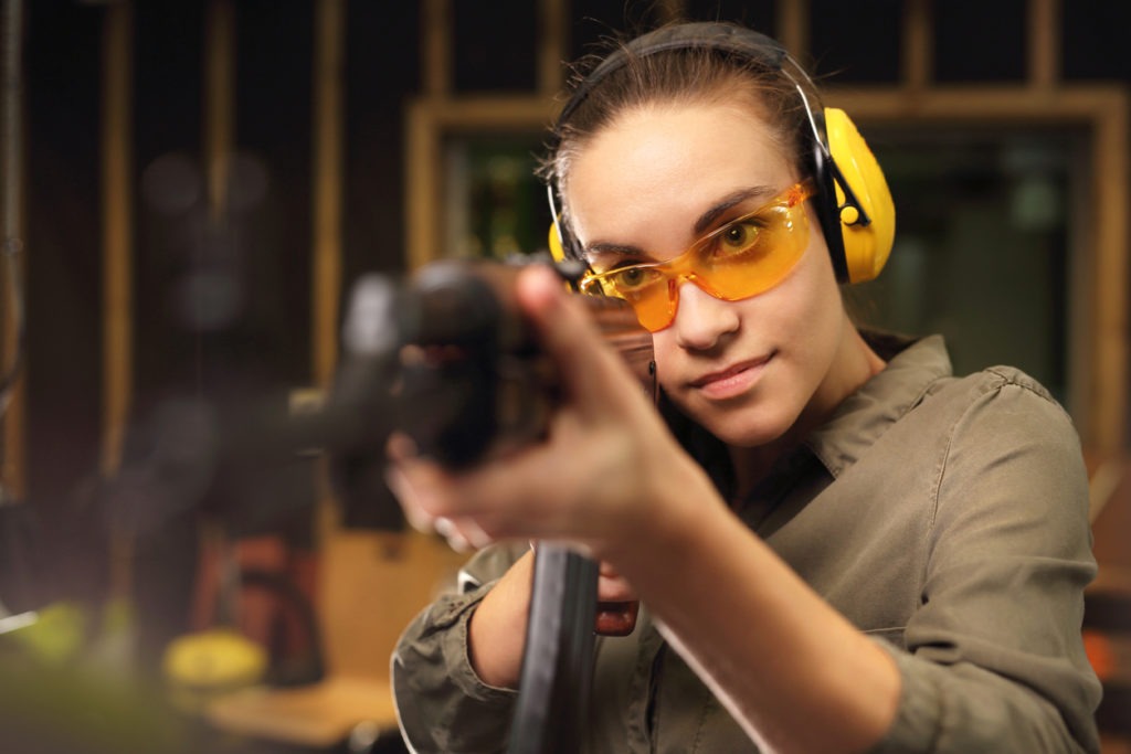Sport shooting.The woman at theshooting range shot from a rifle while safety gears