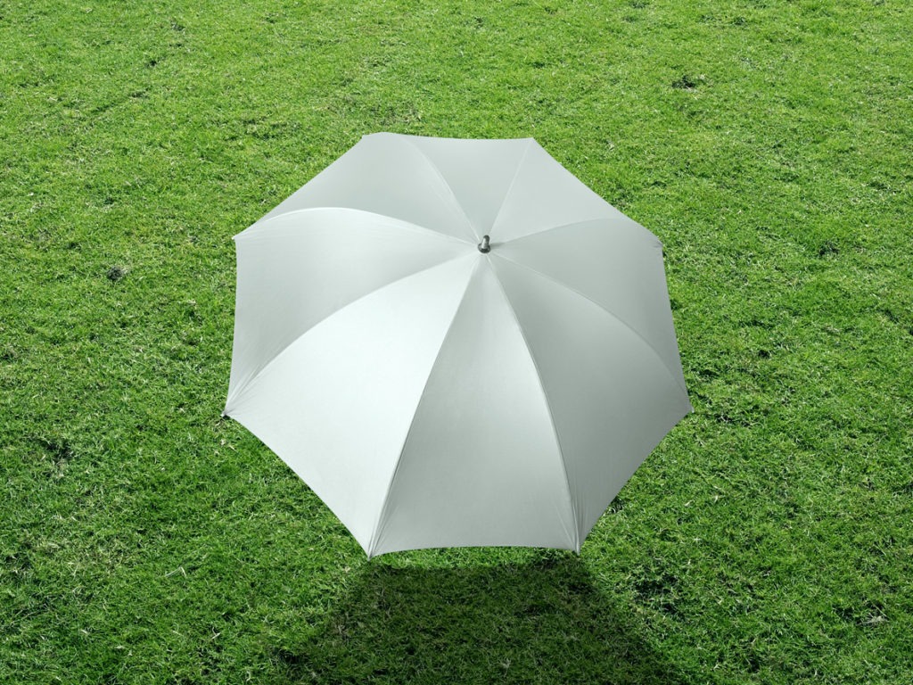 The white sun umbrella place on green grass golf cours