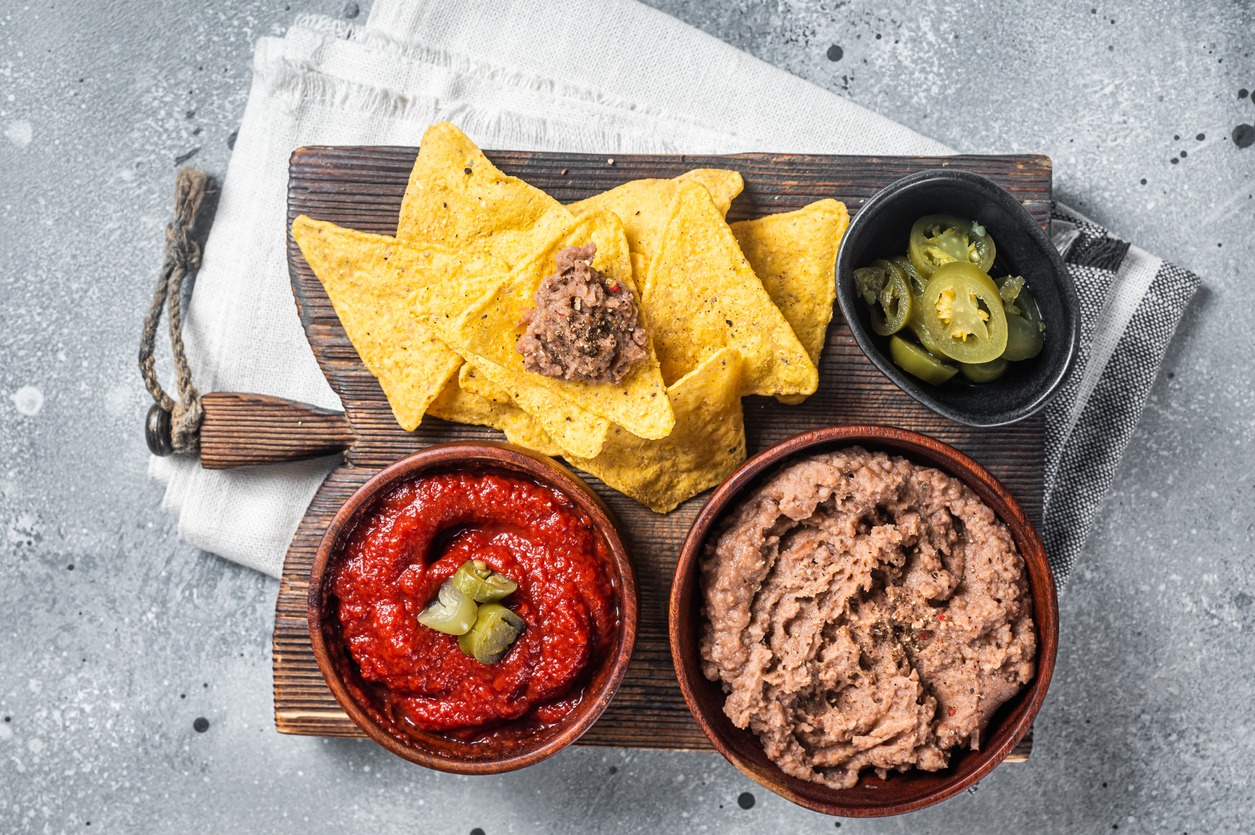 Traditional refried beans from Mexico served with chips, tomato sauce, and jalapenos