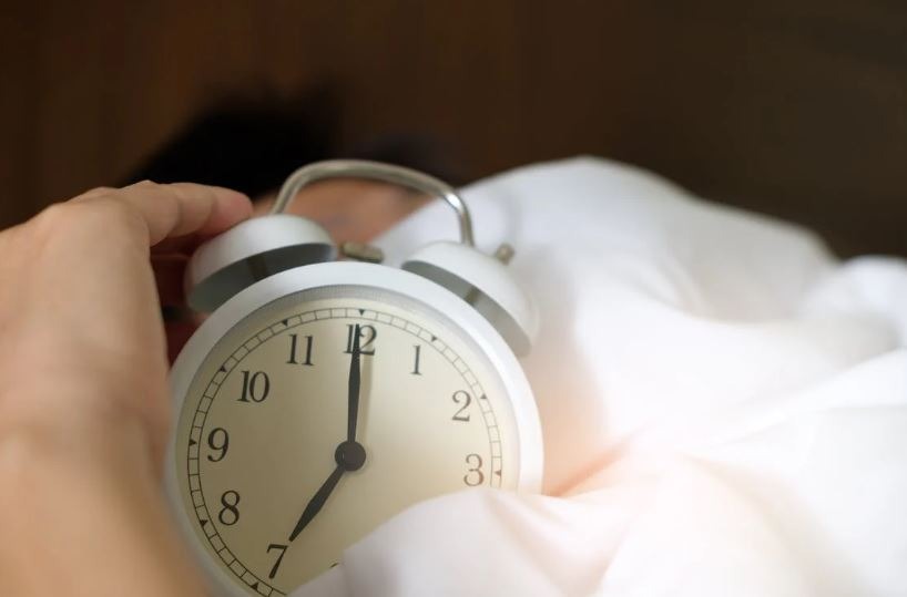 a hand holding an alarm clock