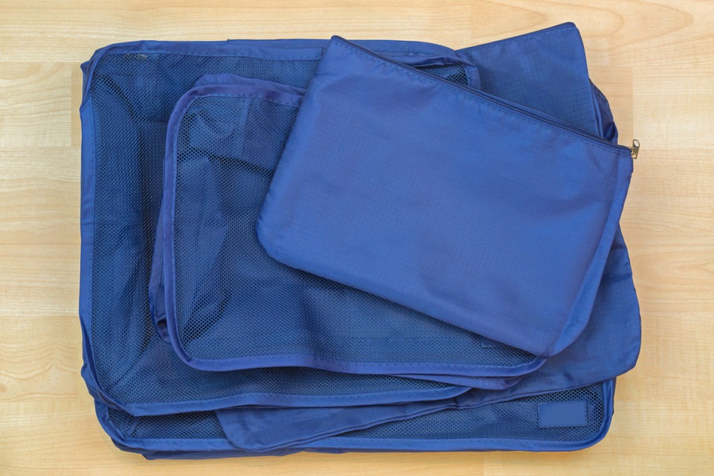 Different blue cube bags, set of travel organizer to help packing luggage easy