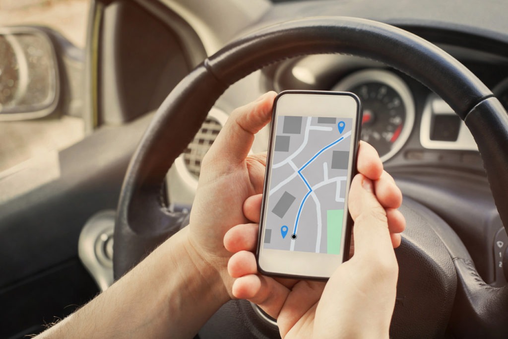 driver using direction navigation on GPS map on the screen of mobile phone