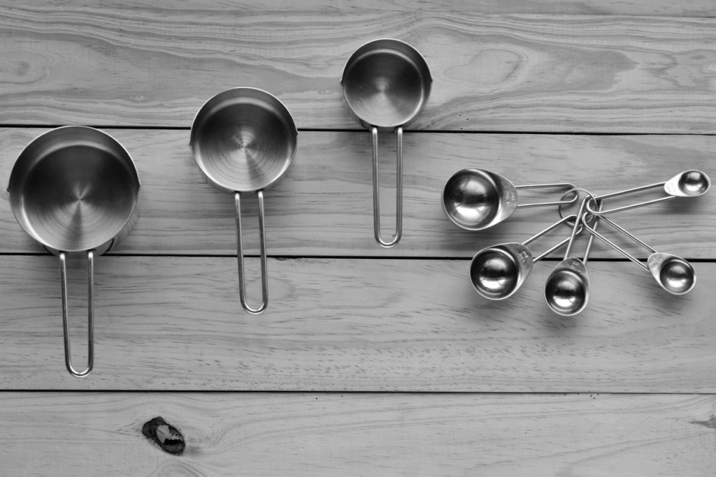Flat lay of stainless steel measuring cups and spoons
