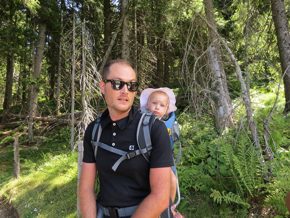 A father hiking while carrying his baby in a baby carrier