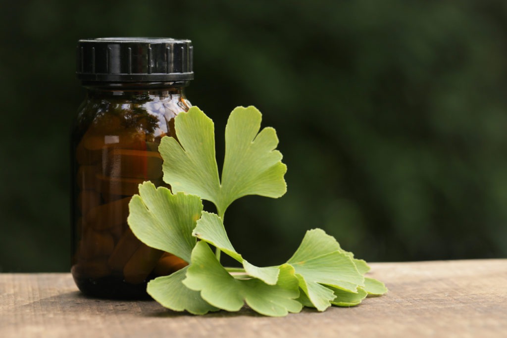 Ginkgo biloba tablets.Alternative medicine and homeopathy. Brown glass jar with pills ,ginkgo biloba leaves