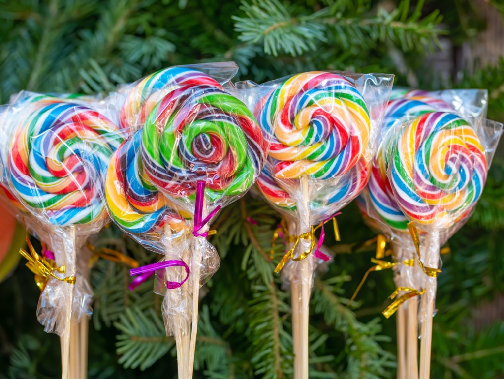 Lollipops or sugar candy on display with pine tree branches in the background