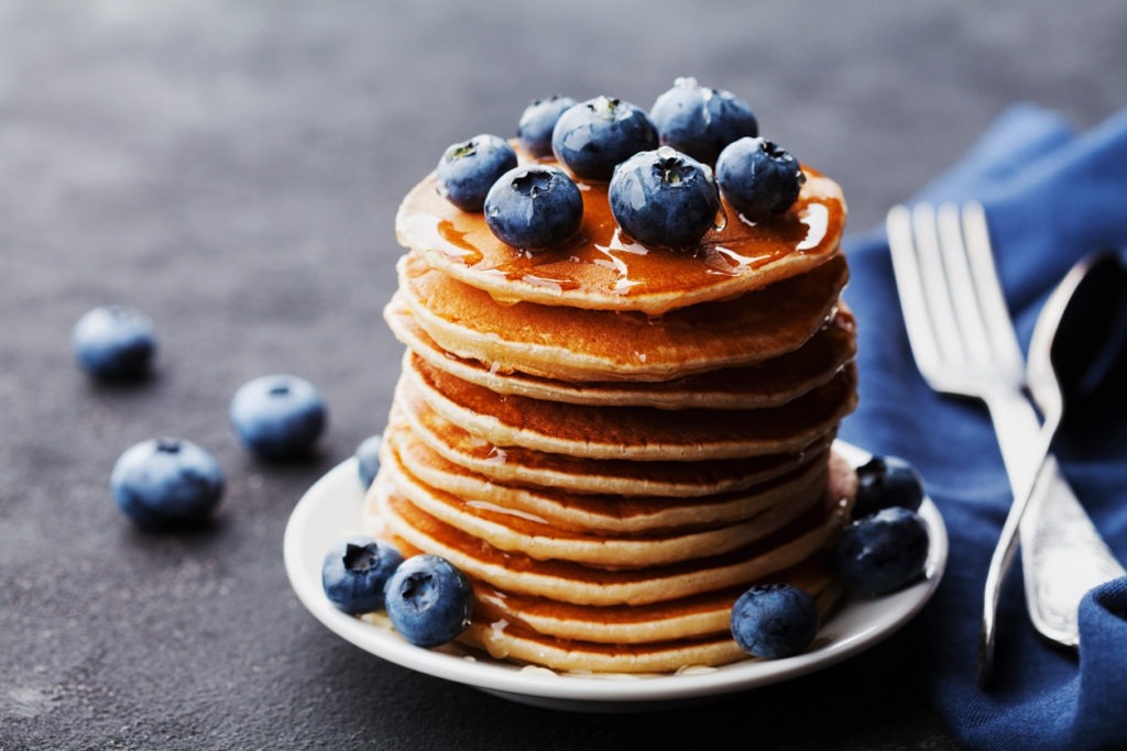 Pancakes or fritters with blueberries and honey syrup