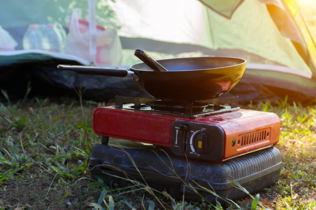 Portable gas stove and a frying pan in the camp with sunlight