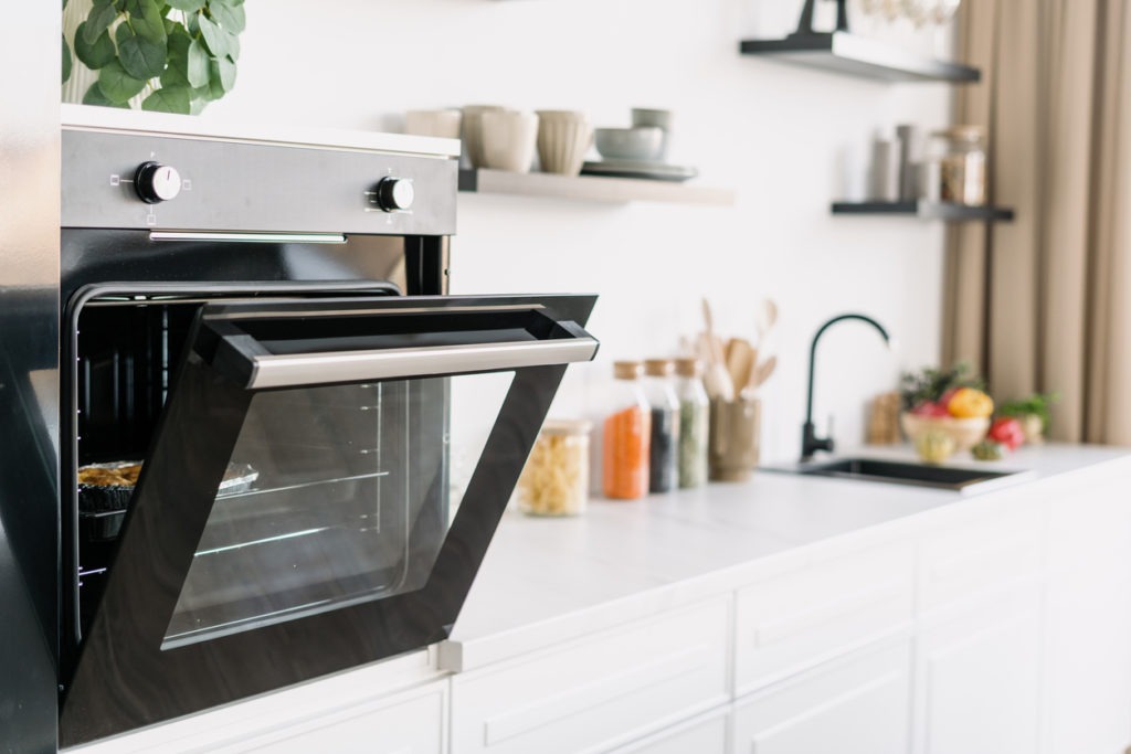 Stylish black oven with open door in kitchen