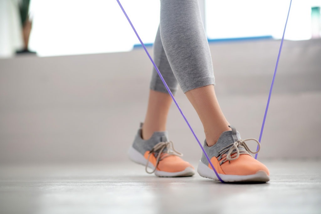 A woman stepping on a rope to check length