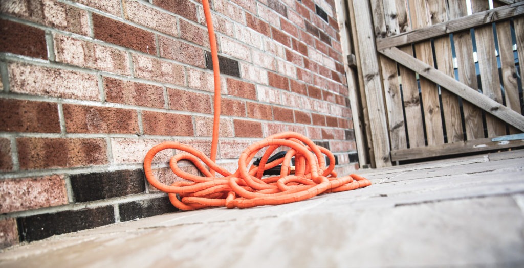 An expandable and flexible garden hose laid down on the floor