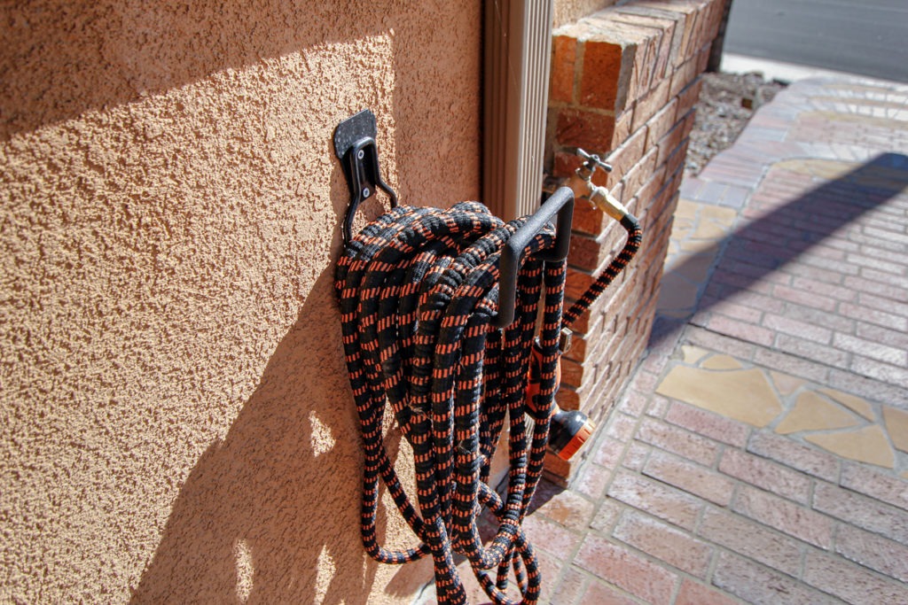 An expandable hose hanging on the wall