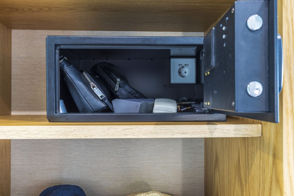 An opened hotel room safe with valuable items
