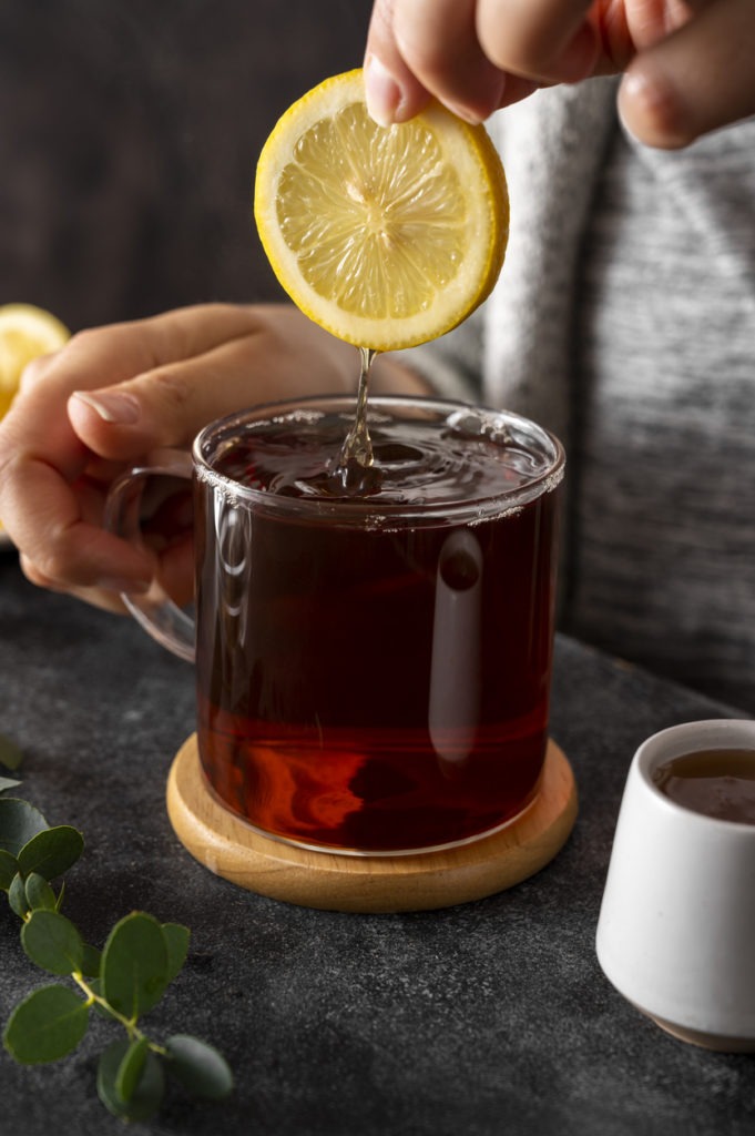 Black tea in glass cup, morning hot drink with lemon and honey