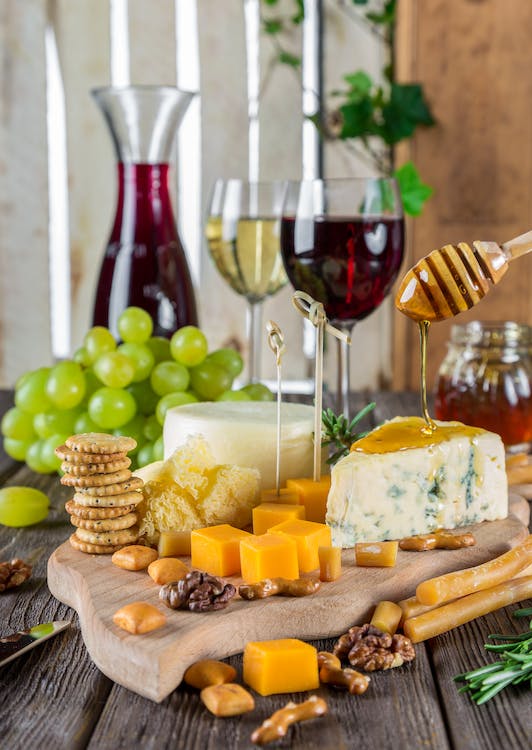 Cheese and other assorted snacks with wine and fruits