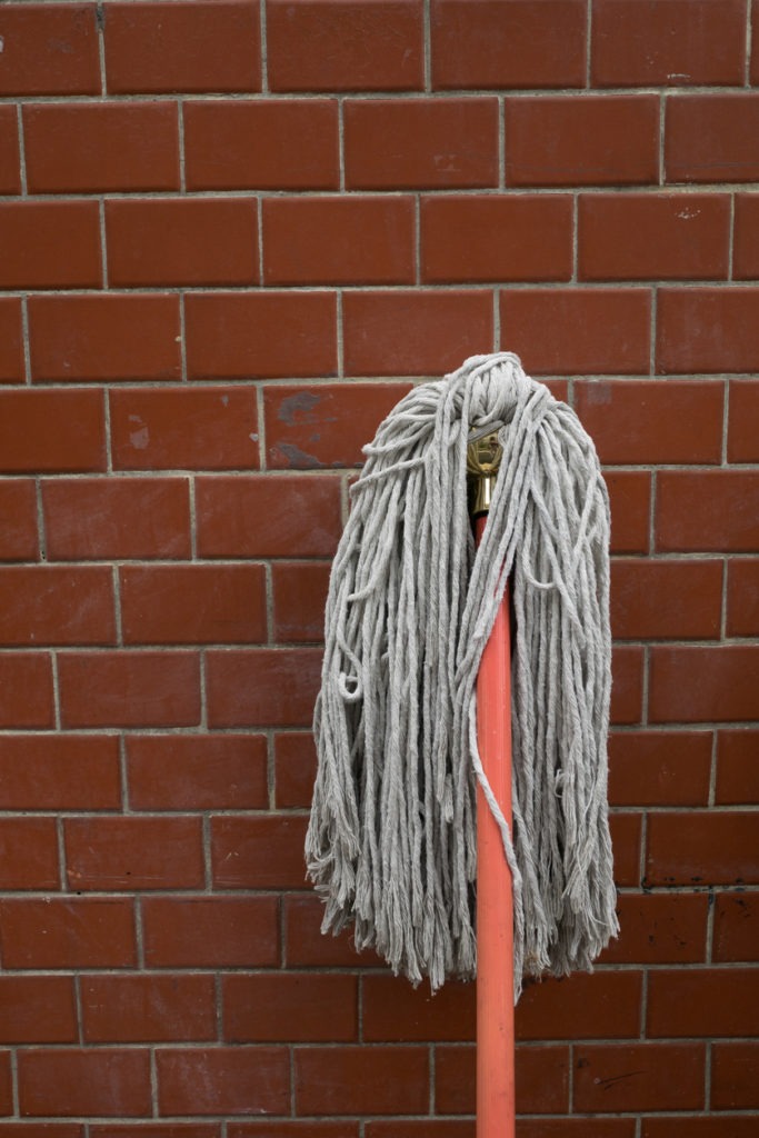 Cotton string mop with a brick wall on the back ground