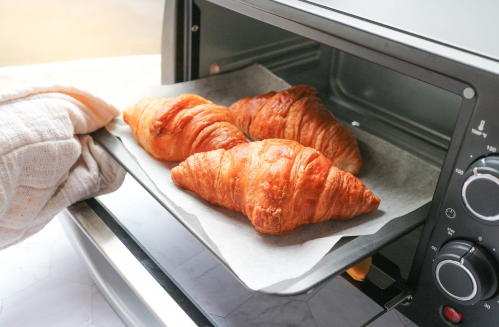 Croissant being taken out from a mini oven