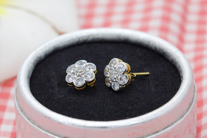 Beautiful golden earrings decorated with diamond in flower shape display in jewelry box