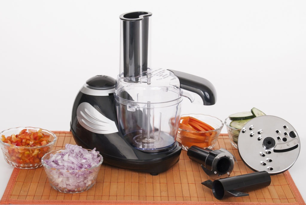 Food processor with accessories on white background