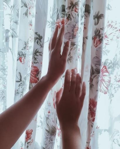 Hands touching a floral curtain